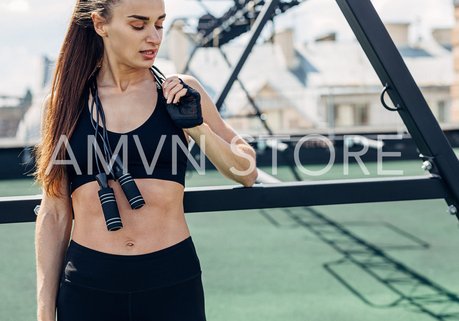 Fitness woman taking a break standing with jumping rope on her neck