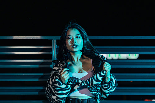 Portrait of an Asian woman posing on a roof and looking at camera