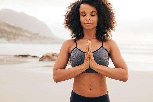 Portrait of fitness woman with her hands joined. Young female with closed eyes practicing yoga meditation.