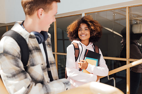 Two classmates looking at each other while climbing college stairs