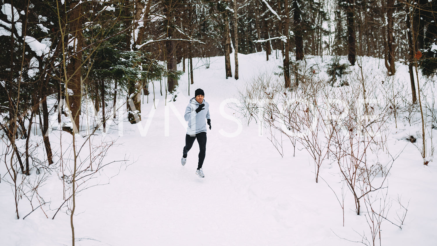 Sportsman running in forest. Young man exercising at winter.	
