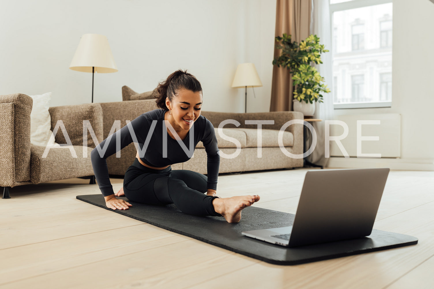 Mixed race woman repeating exercises from fitness instructor online	