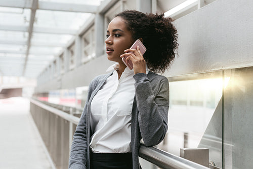 Young woman talking on cellphone at airport