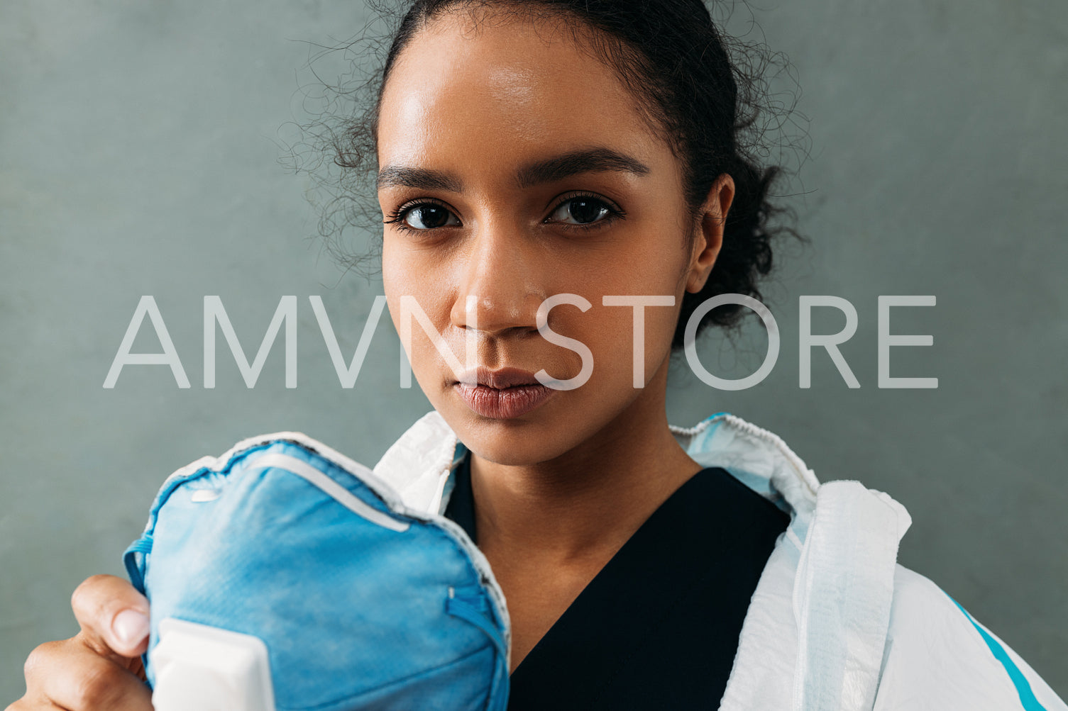 Close up portrait of a tired female nurse holding a respirator looking at camera	