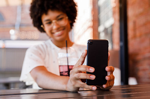 Unrecognizable smiling woman holding a mobile phone and taking selfie