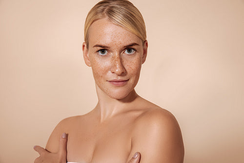 Young woman with perfect skin with freckles posing in studio and