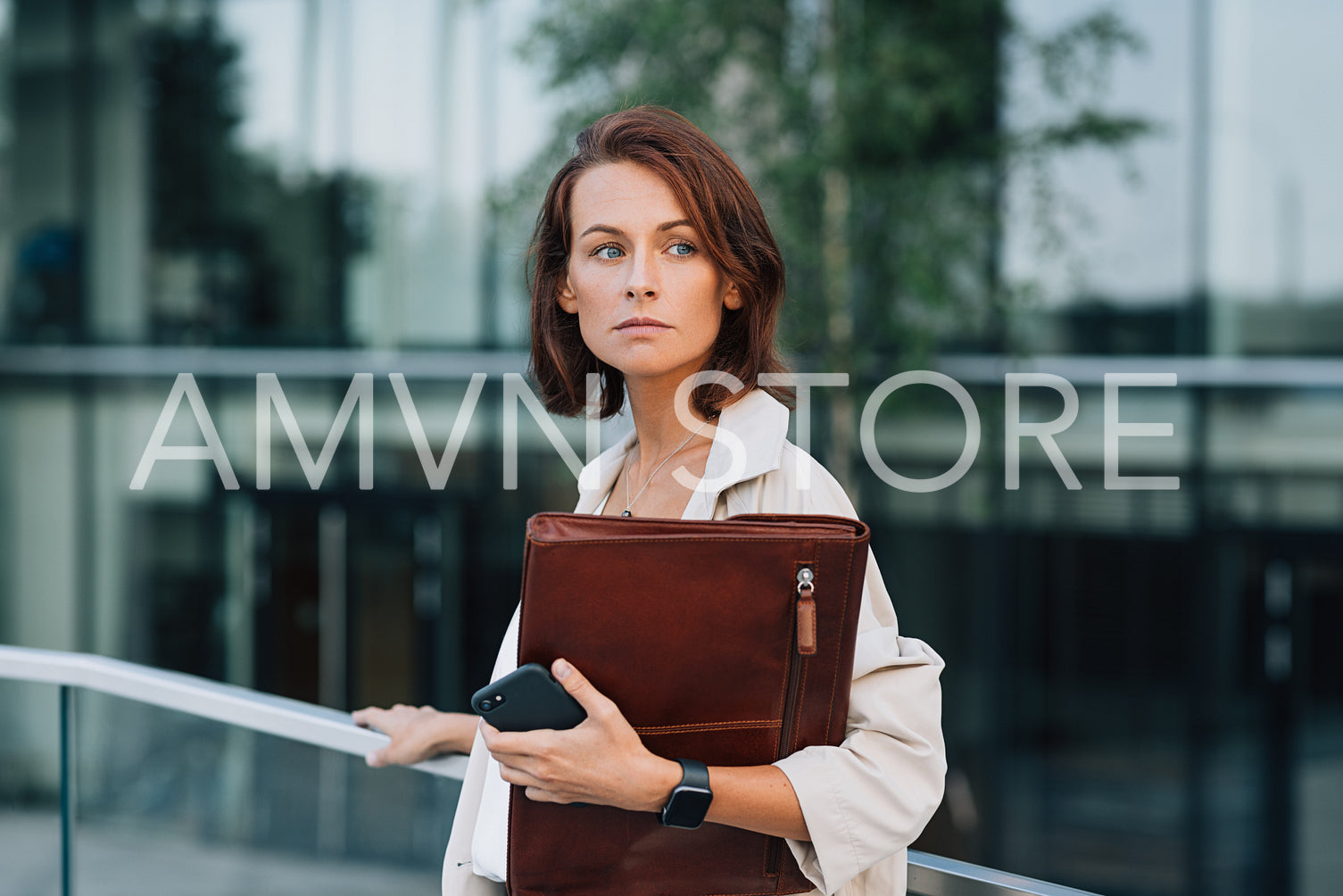 Portrait of a confident businesswoman with ginger hair holding a leather folder