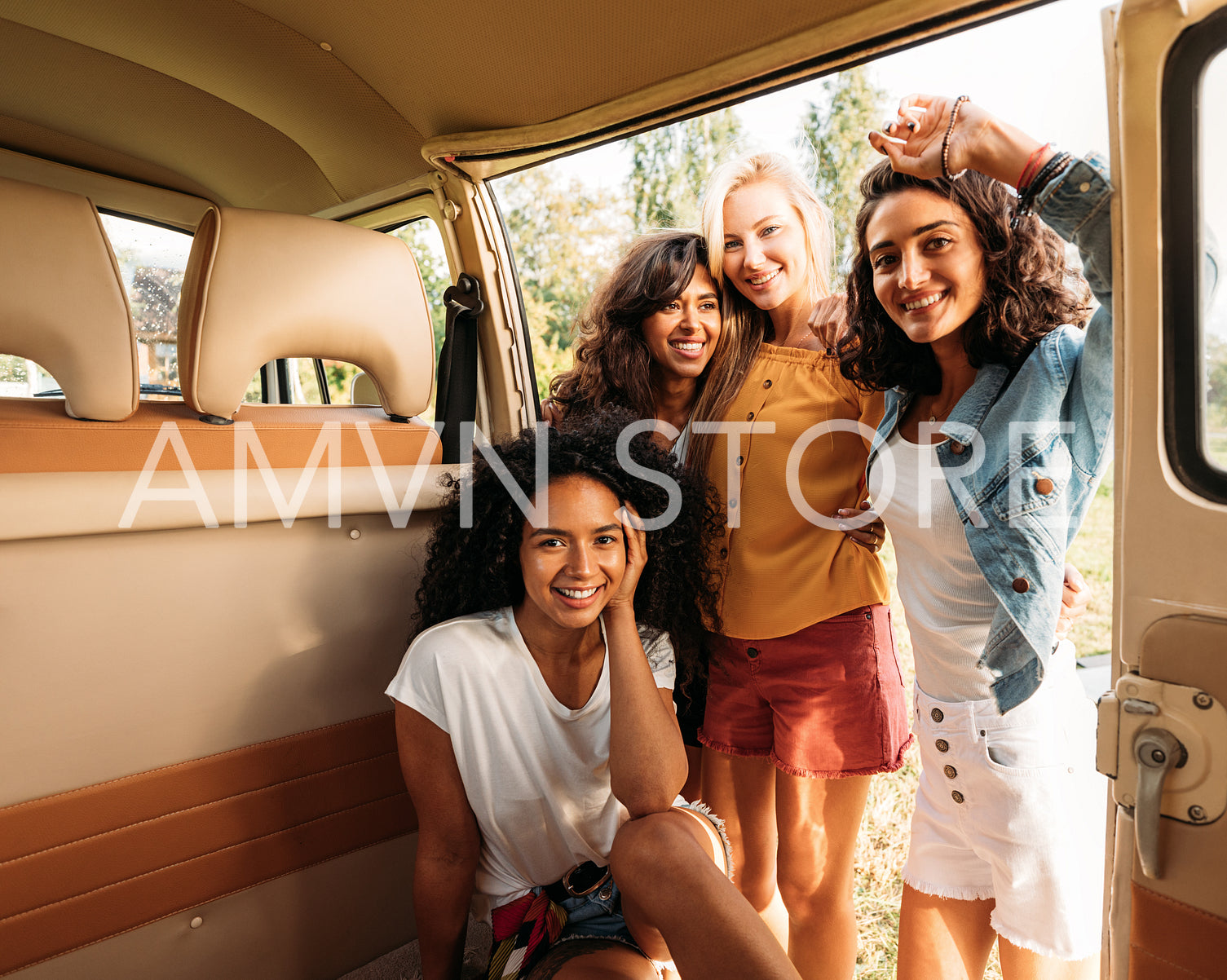 Multi-ethnic group of female friends spending time together at camper van