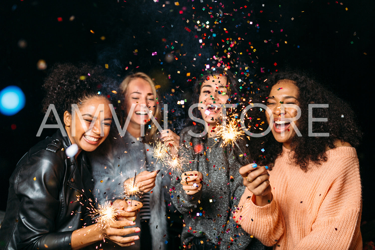 Happy friends. Group of smiling women holding sparklers under confetti	