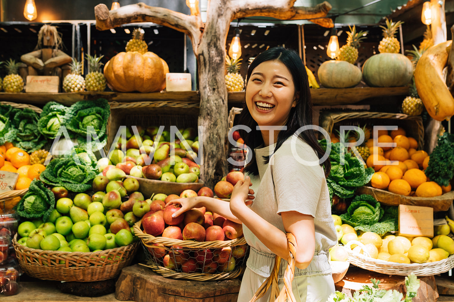 Laughing Asian woman on an outdoor market. Smiling female buying organic food.