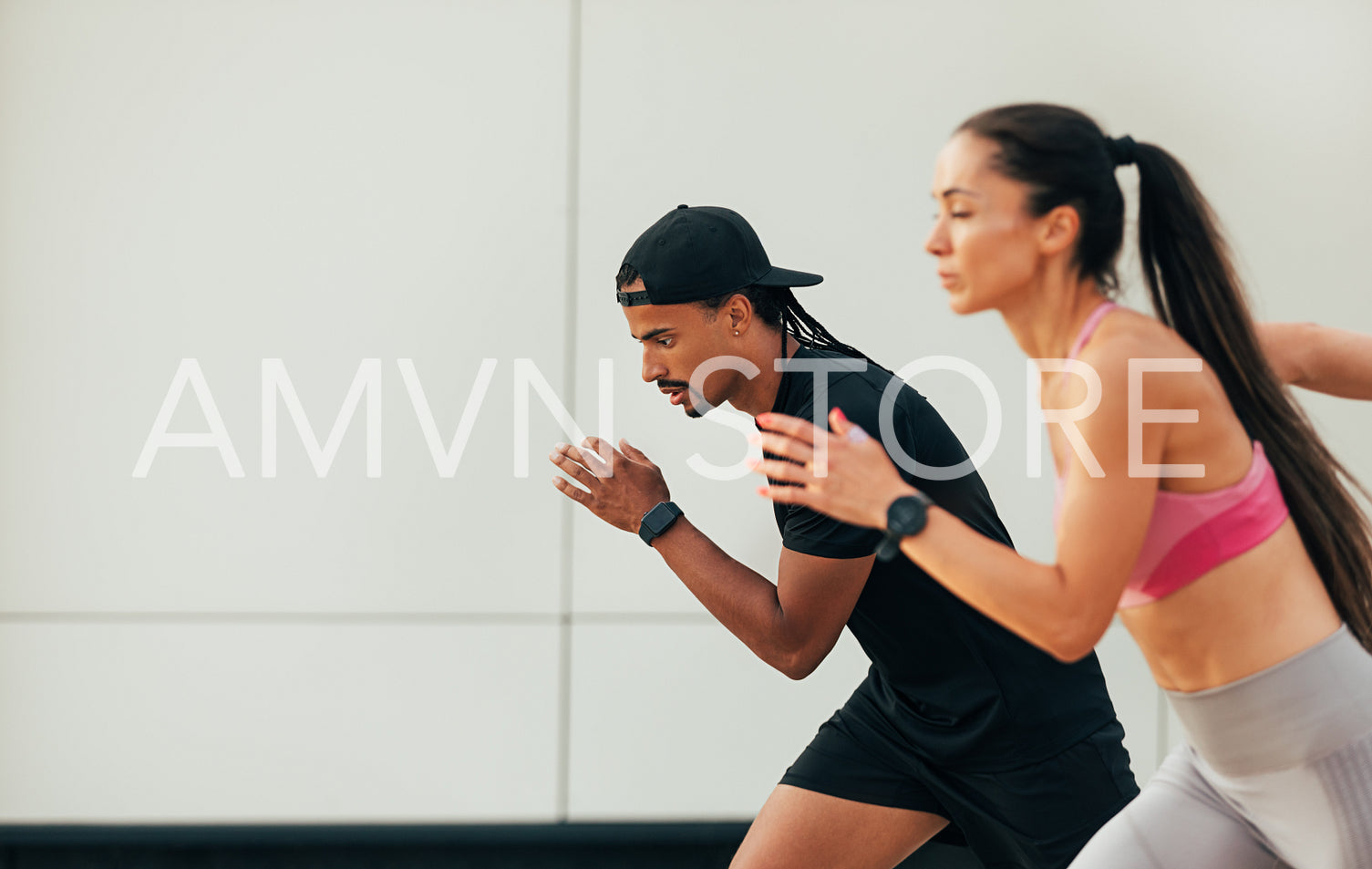 Two athletes prepare to run. Male and female sprinters are running outdoors.