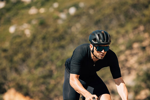 Male cyclist in black sportswear during training