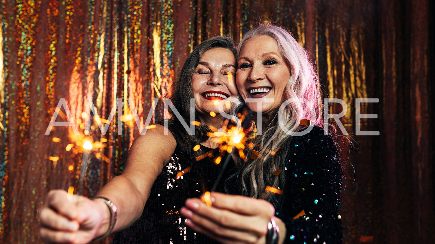 Two senior girlfriends having fun together holding sparklers