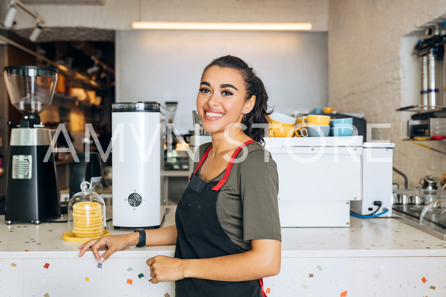 Beautiful waitress standing at the counter wearing apron looking away	