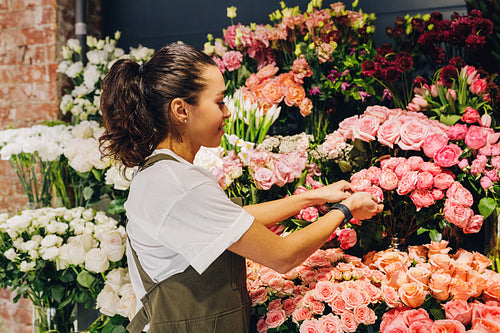 Young woman caring for flowers in a flower shop