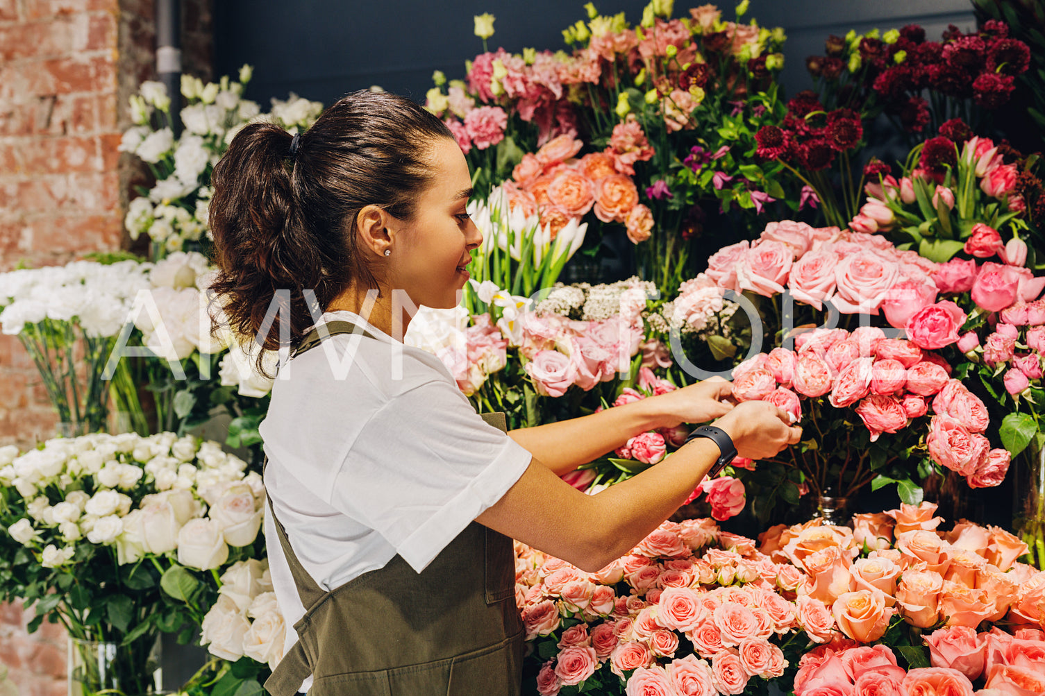 Young woman caring for flowers in a flower shop	