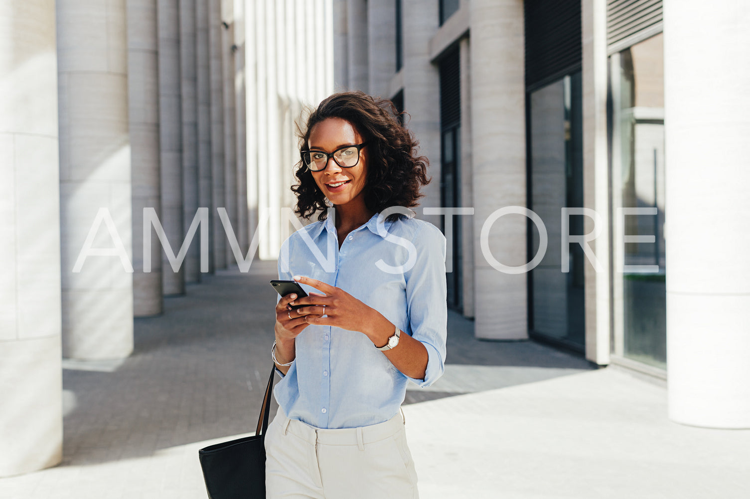 Woman wearing eyeglasses holding a smartphone in hands	