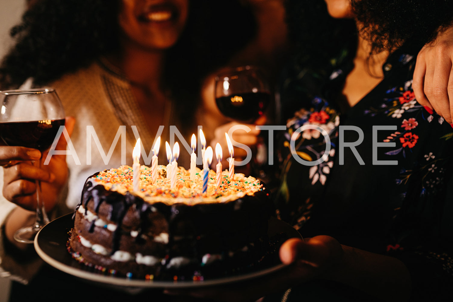 Cropped shot of friends celebrating birthday, holding cake	