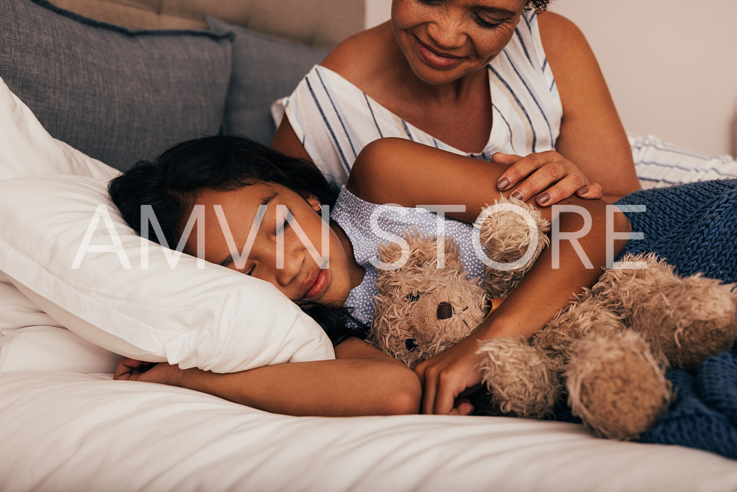 Smiling mature woman sitting near her granddaughter while she going to sleep