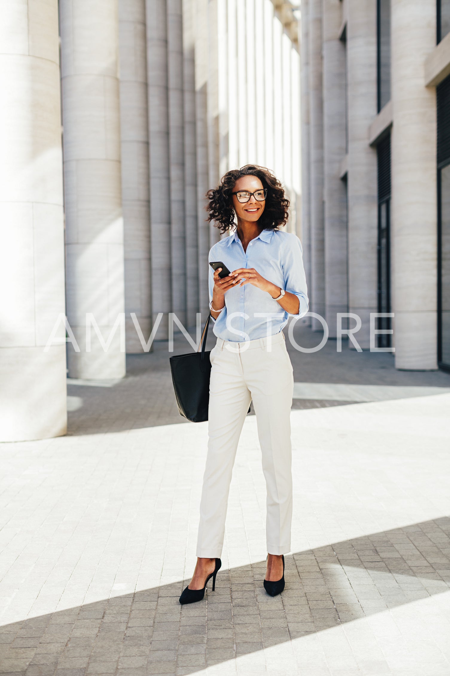 Businesswoman wearing formal clothes standing in front of a modern office building	