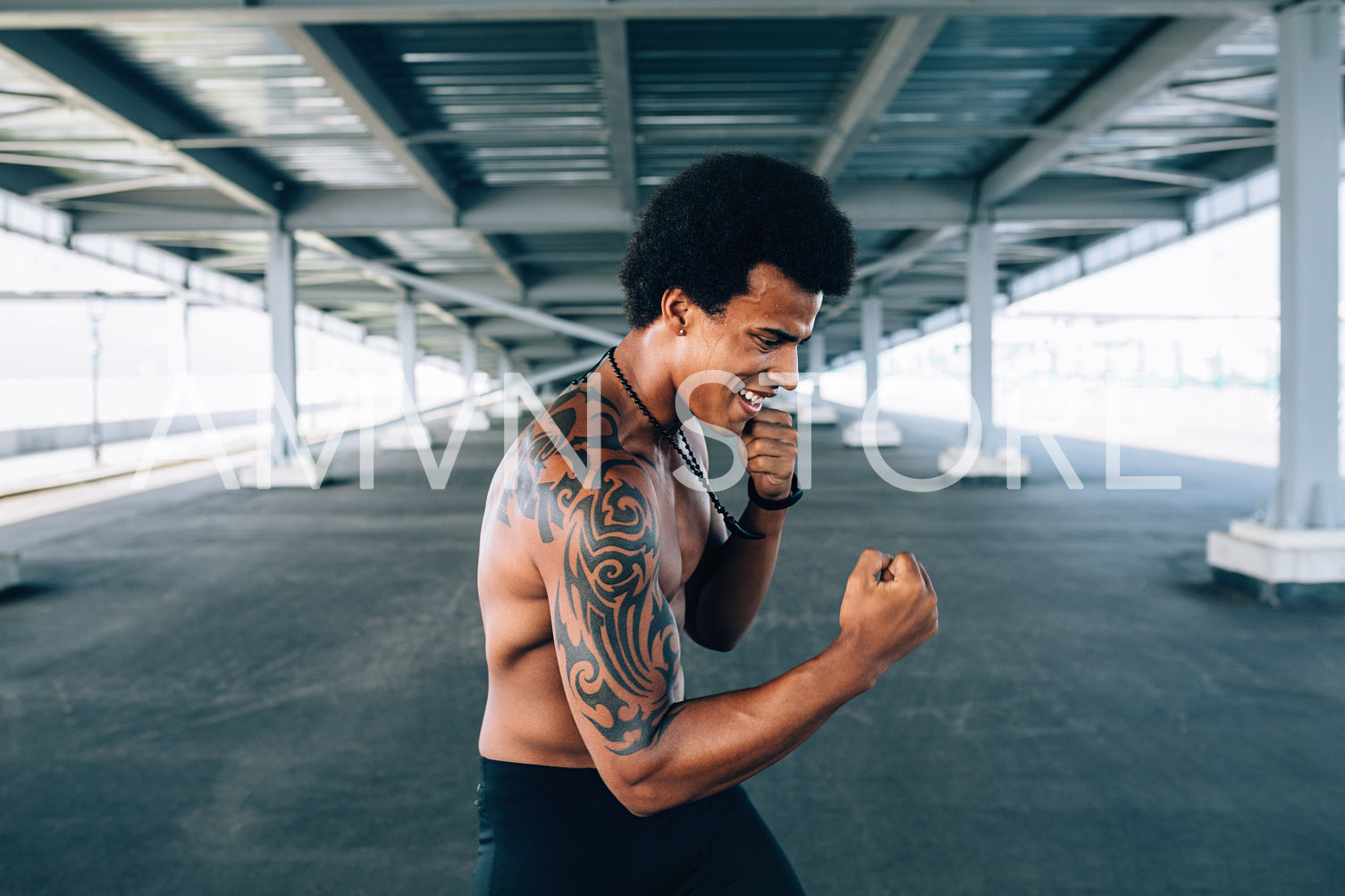 Side view of young athlete doing shadow boxing outdoors	