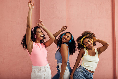 Three females in colorful clothes having fun together while list