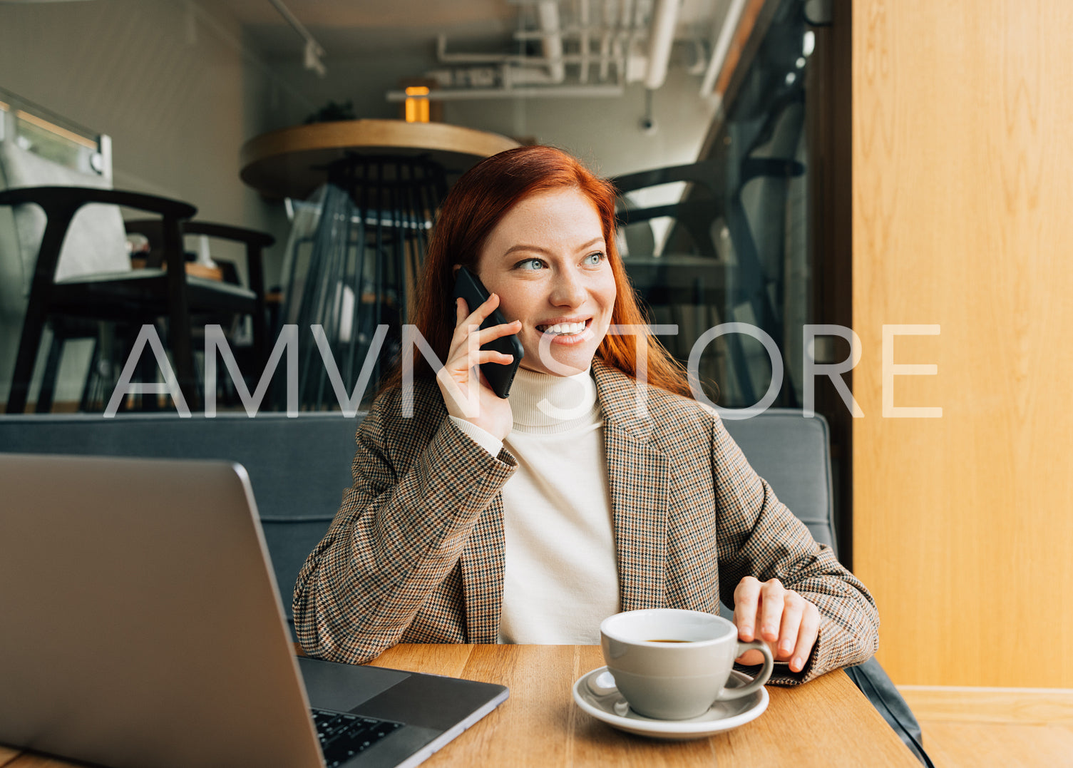 Smiling redhead female in formal attire working remotely from the cafe