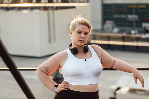 Portrait of a confident plus-size woman standing on a roof