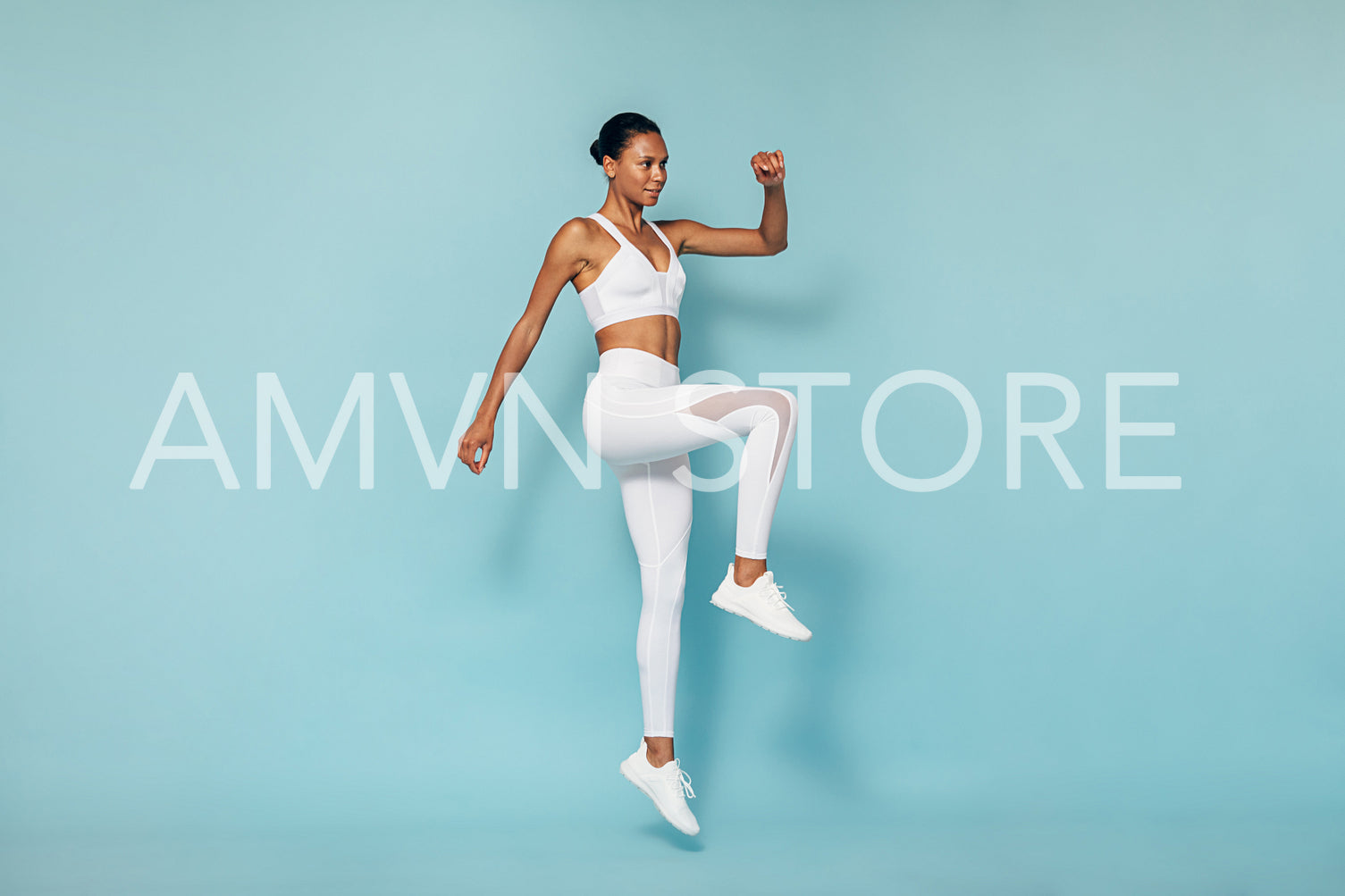 Young woman in sports wear warming up before training in studio	