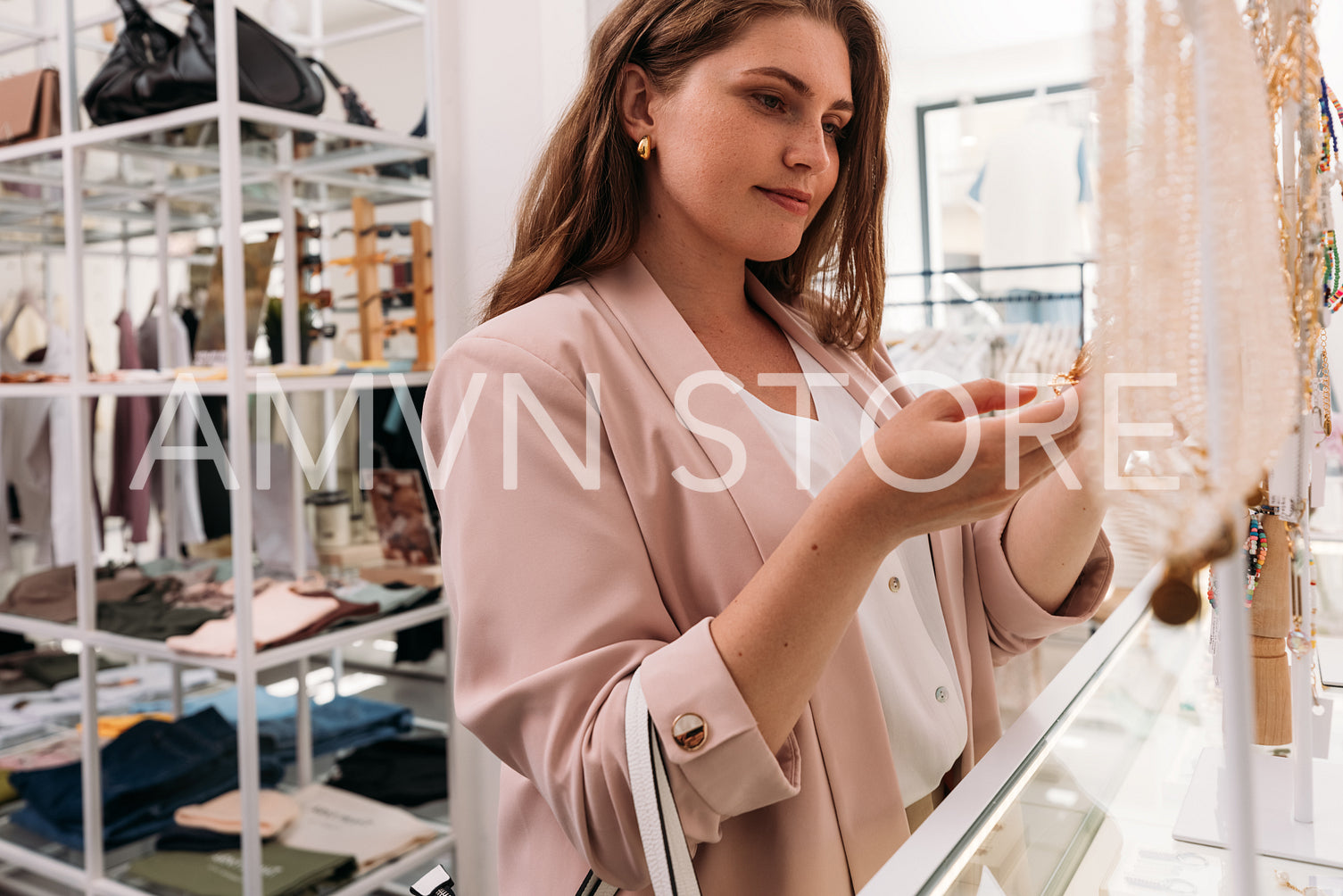 Close up of stylish woman looking on a necklace at a display cas