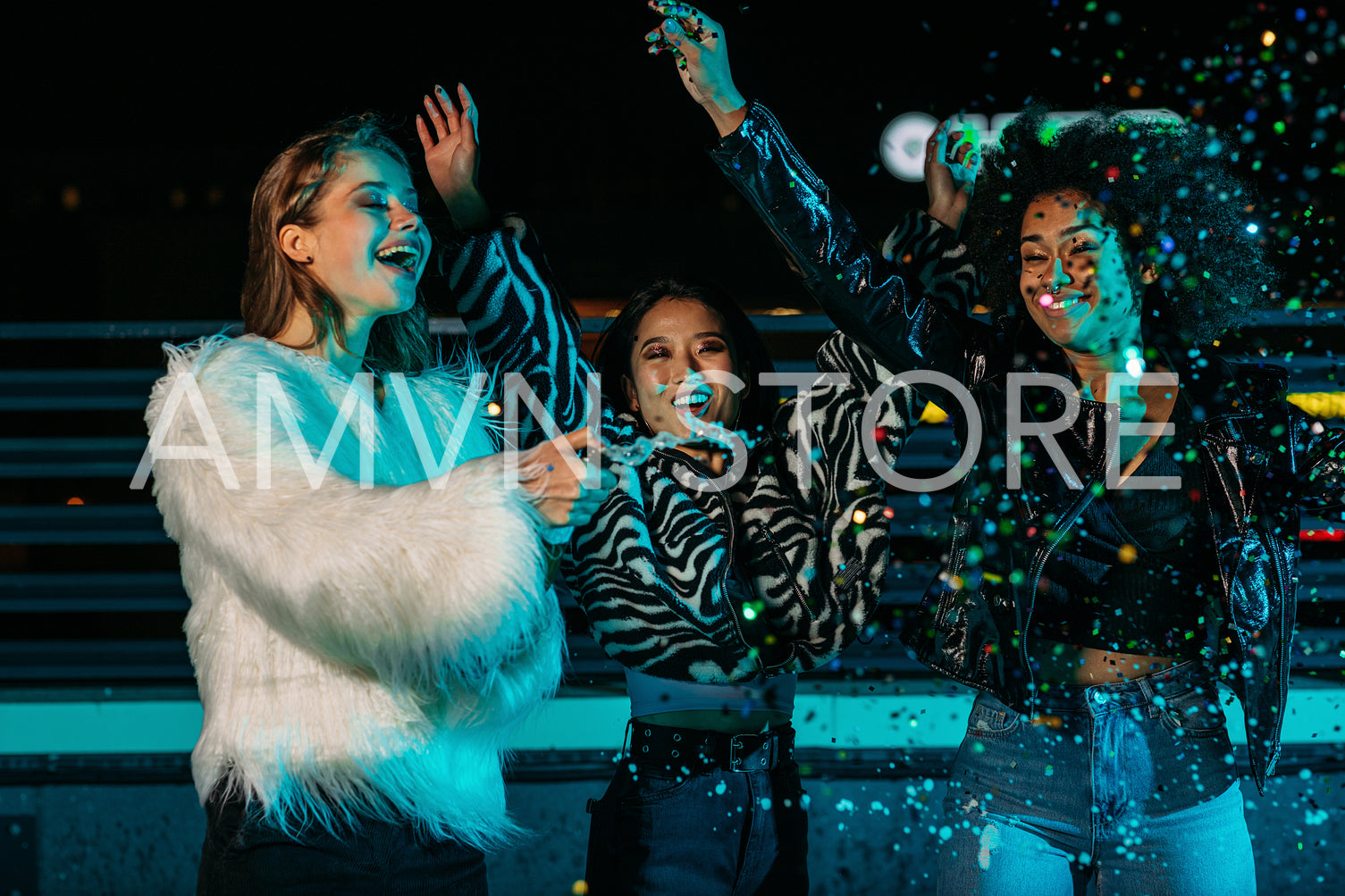 Three girlfriends having fun on roof with champagne an confetti	