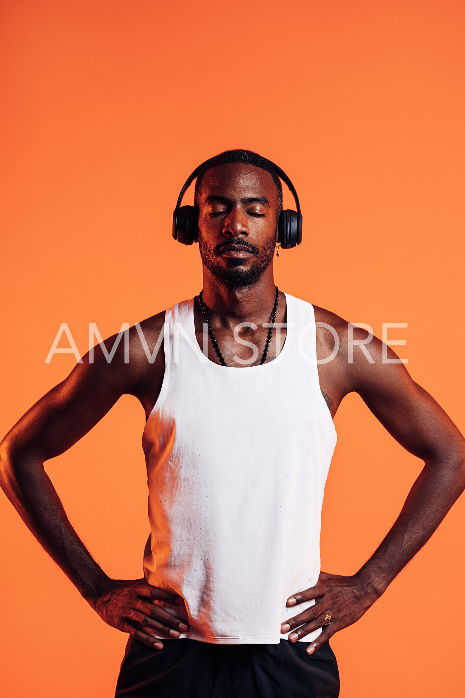 African American male athlete listening music through wireless headphones. Man in sportsclothes relaxing during fitness training.