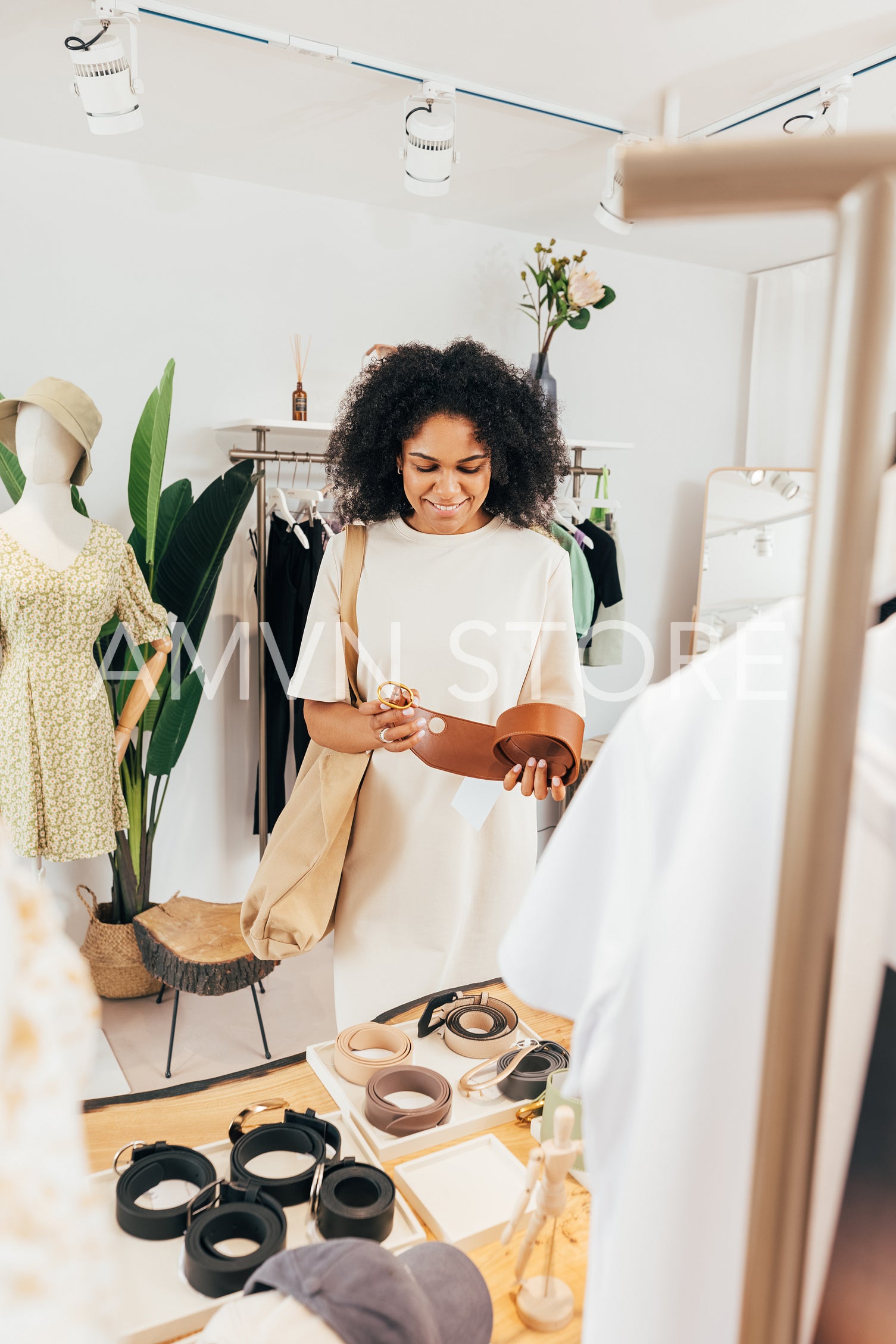 Stylish woman choosing accessories for clothes in a small local boutique