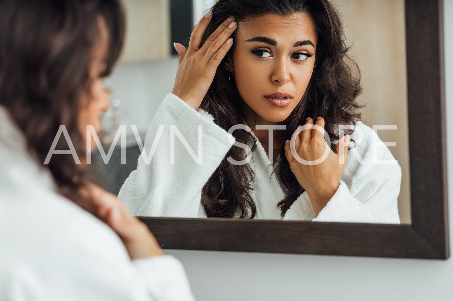 Middle East woman looking at mirror reflection taking care of her skin in bathroom	