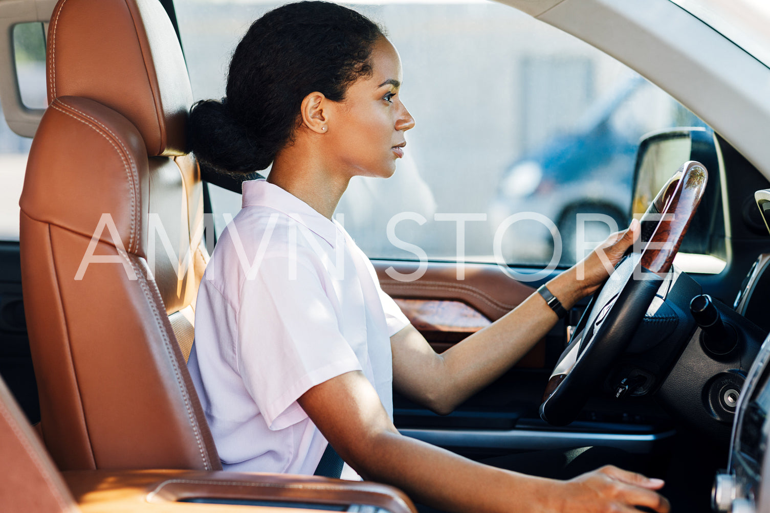 Side view of woman shifting car with manual transmission. Young female driver looking forward.	