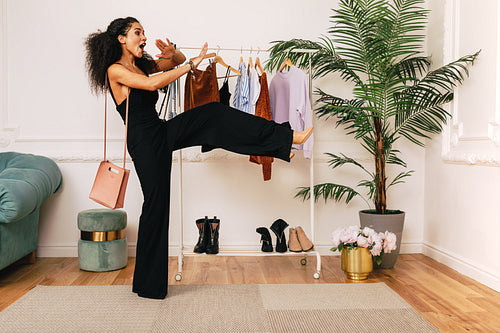 Fashion stylist laughing in studio at clothes rack