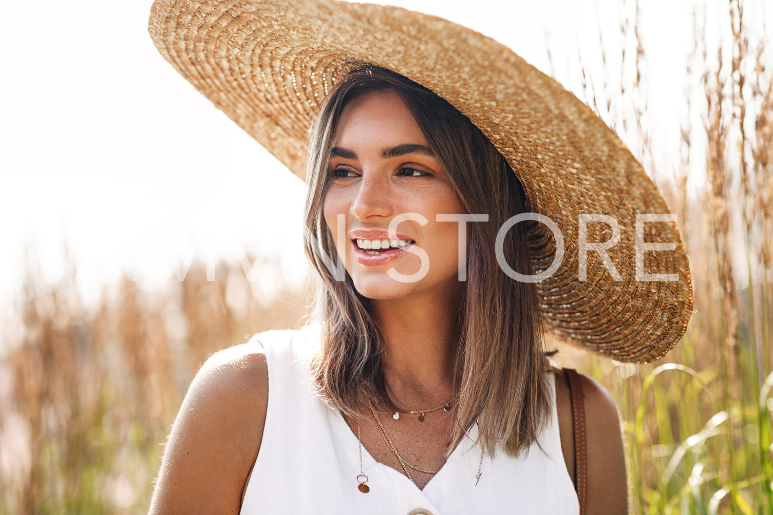 Portrait of a cheerful woman wearing big straw hat	