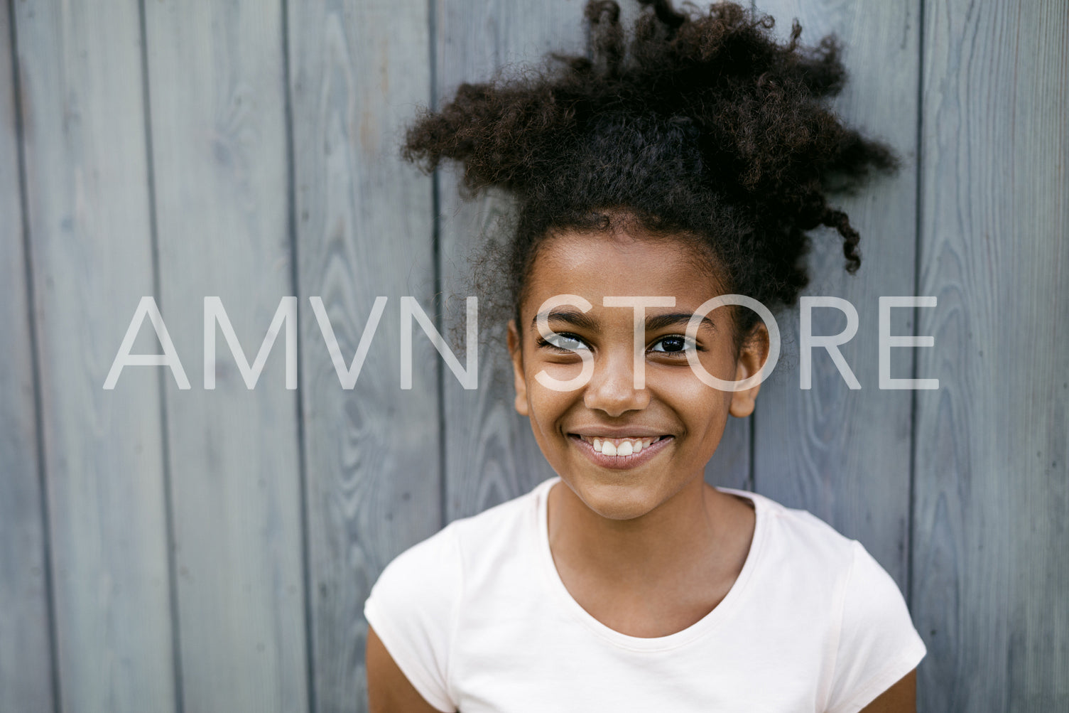 Portrait of a funny smiling girl, standing at wall outdoors	