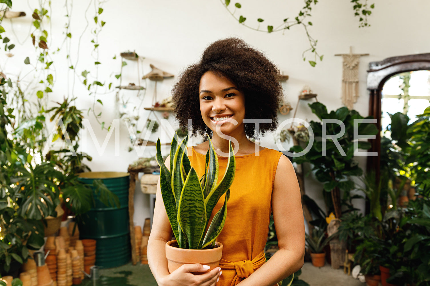 Portrait of beautiful woman florist looking at camera and smiling in her workshop	