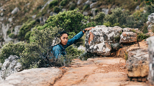 Woman grabs a stone, climbing up and looking away