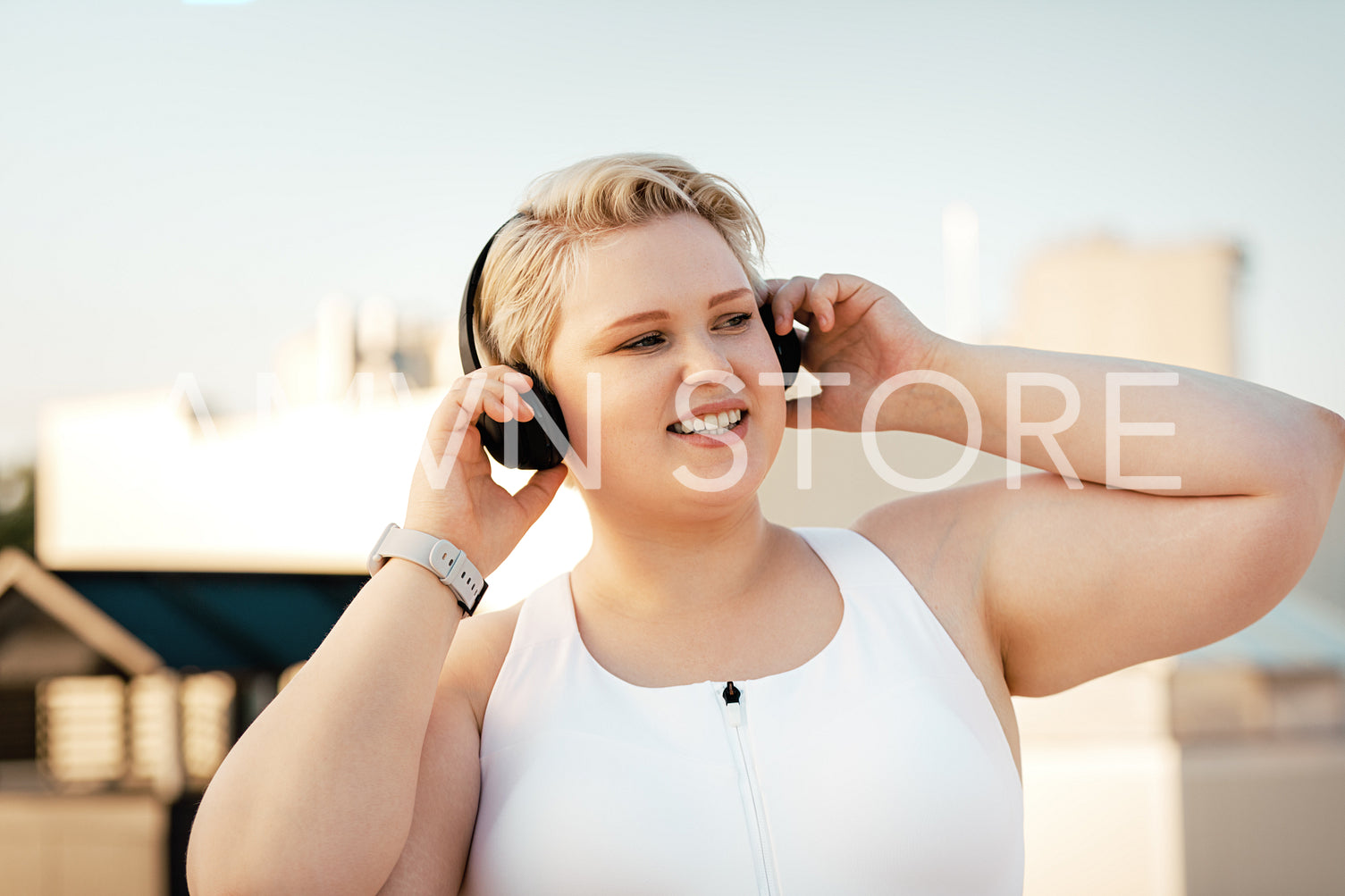 Plus size woman listening to music on the roof during training	