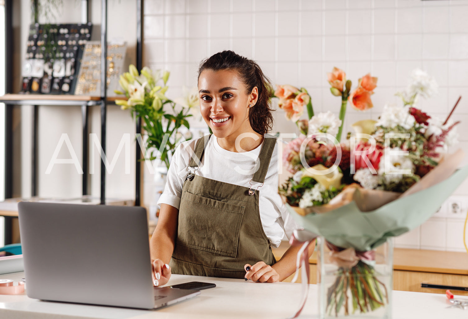 Florist woman standing at counter and looking at camera	