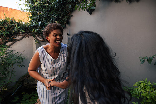 Laughing grandma looking at her granddaughter while dancing