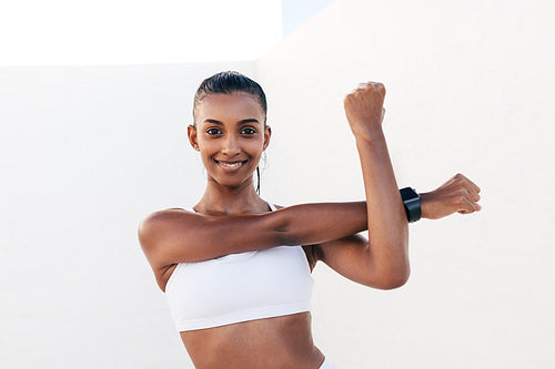 Smiling woman flexing her hands before exercises. Young slim female warming up her hands and looking at the camera.