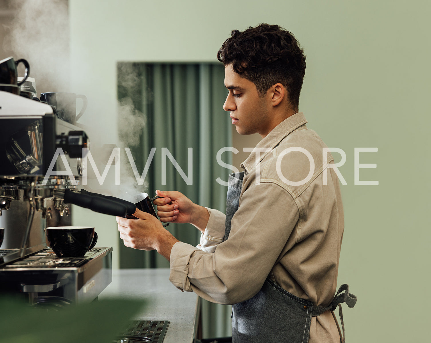 Side view of a male barista in an apron using a coffee machine. Barista using preparing cappuccino.