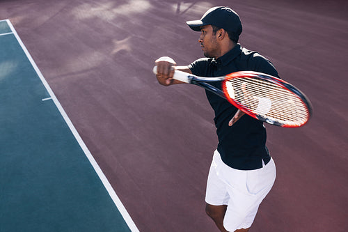 Tennis player on hard court exercising at sunset