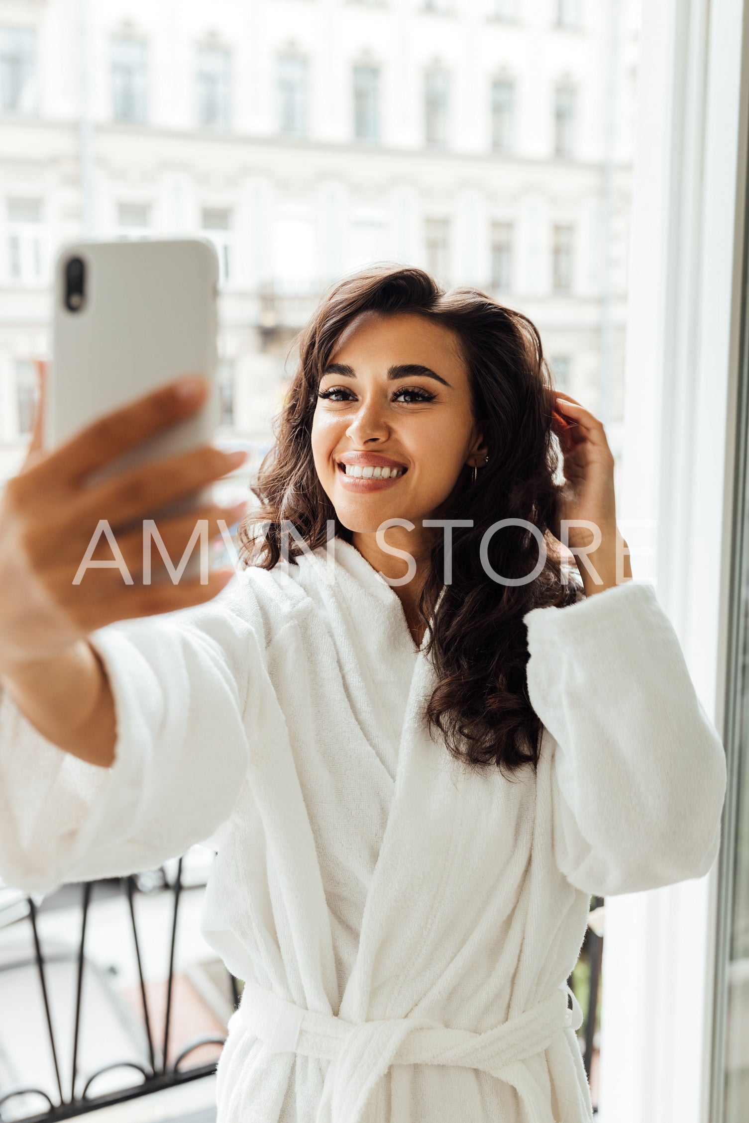 Beautiful brunette taking a selfie while standing on balcony	