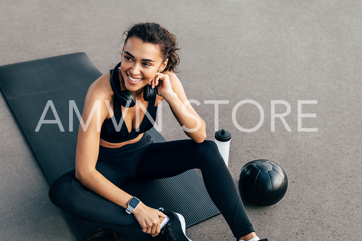 Healthy fit woman in sportswear resting on a mat after exercising at evening	