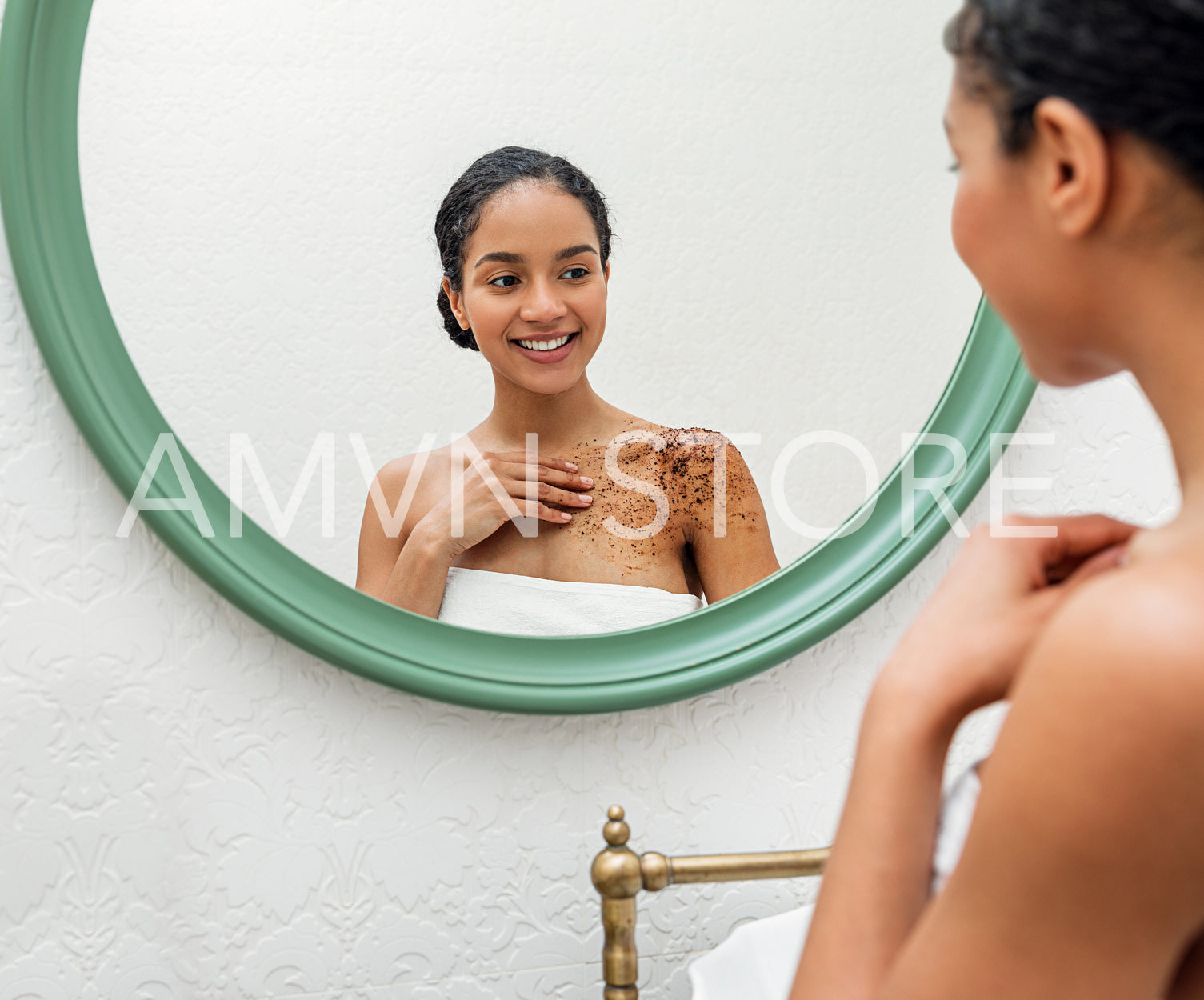 Smiling woman applying coffee bean body scrub in bathroom	