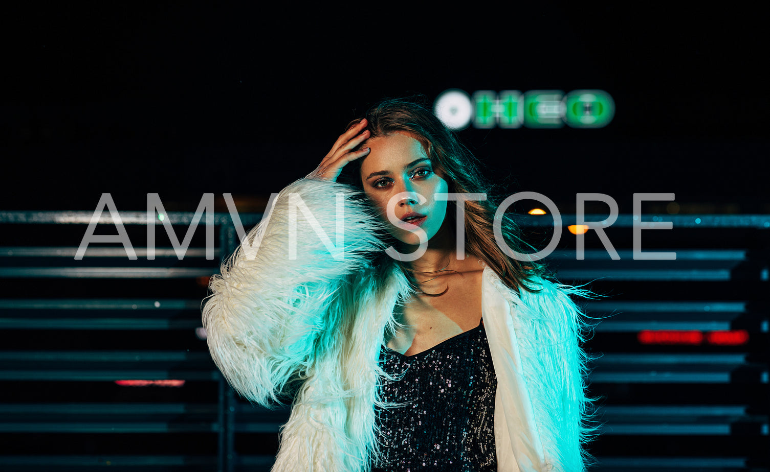 Portrait of a young woman posing outdoors at night wearing stylish clothes	